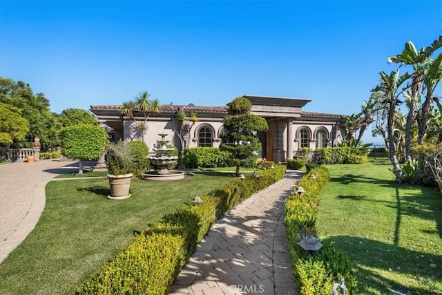 mediterranean / spanish house featuring a front lawn