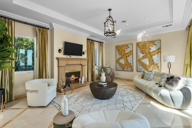 living room featuring a raised ceiling, ornamental molding, light tile patterned floors, and a chandelier