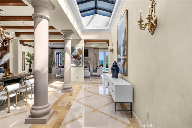 entrance foyer featuring decorative columns, lofted ceiling, and an inviting chandelier