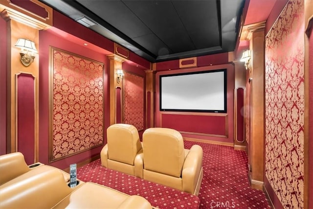 home theater room with carpet flooring, a tray ceiling, and decorative columns