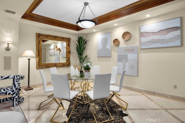 tiled dining room featuring a raised ceiling and ornamental molding