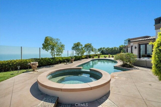 view of pool featuring a patio area and an in ground hot tub