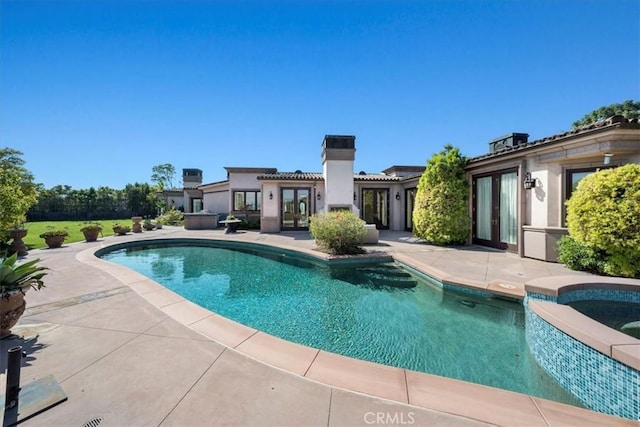 view of swimming pool featuring a jacuzzi and a patio area