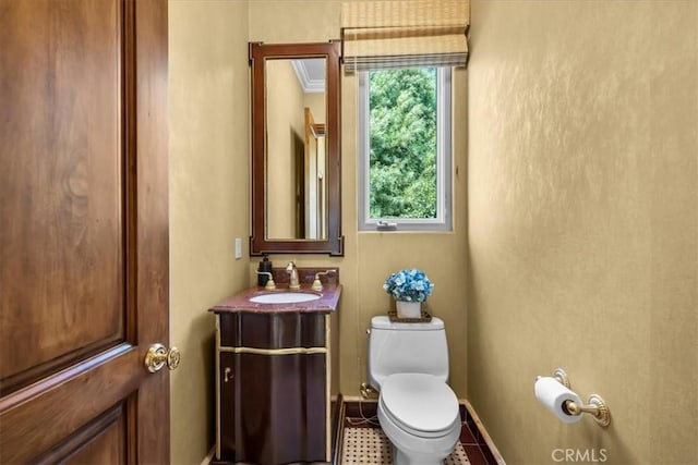 bathroom with tile patterned floors, vanity, toilet, and crown molding