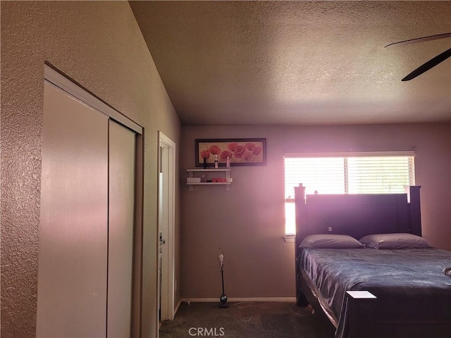 carpeted bedroom featuring ceiling fan and a textured ceiling