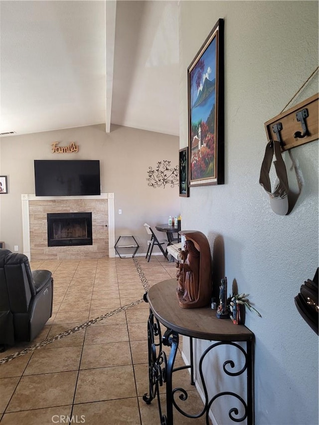 tiled living room with vaulted ceiling with beams and a tile fireplace