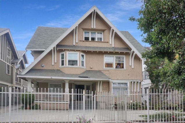 view of front of house with roof with shingles and a fenced front yard