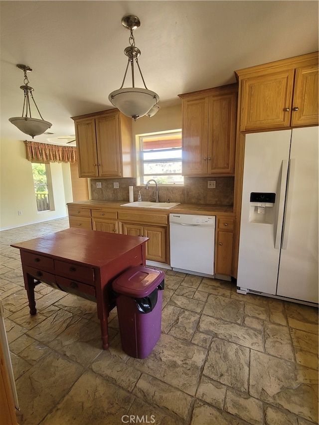 kitchen featuring tasteful backsplash, white appliances, decorative light fixtures, and sink