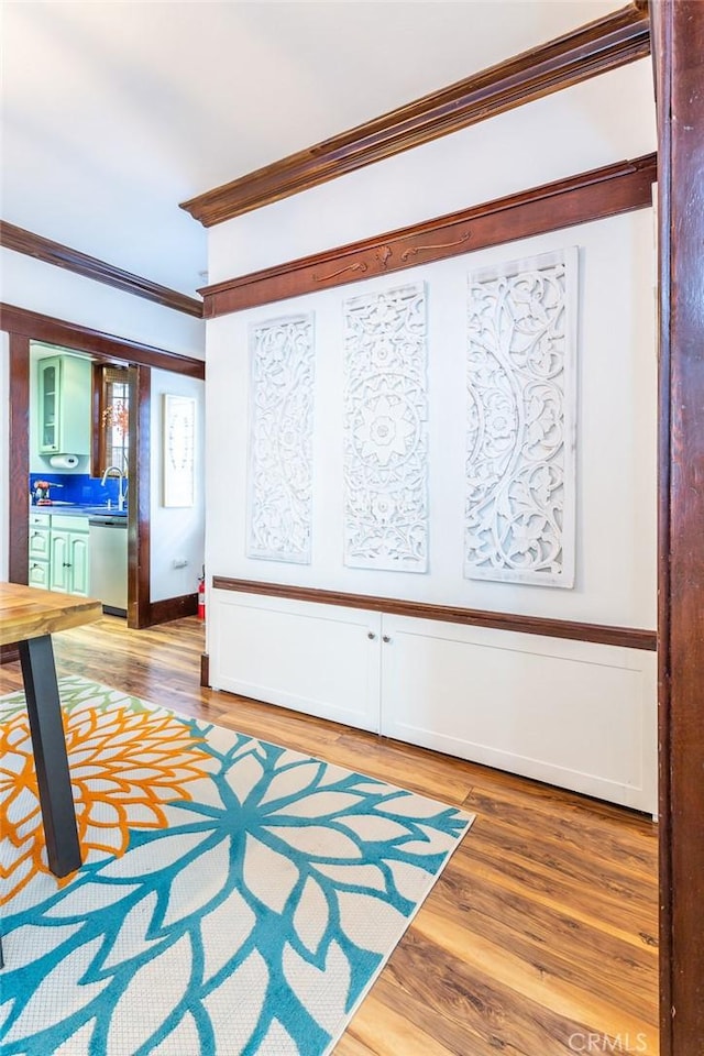 interior space with crown molding, hardwood / wood-style flooring, and sink