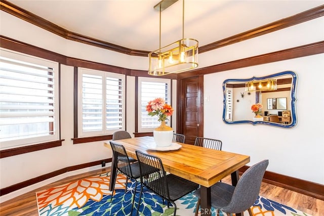 dining area featuring hardwood / wood-style floors and crown molding