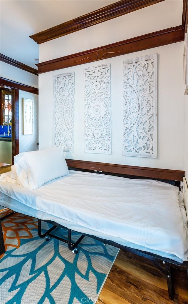 bedroom with wood-type flooring and crown molding