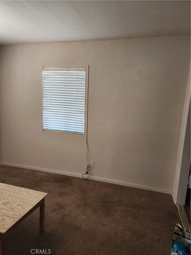 unfurnished room with dark carpet