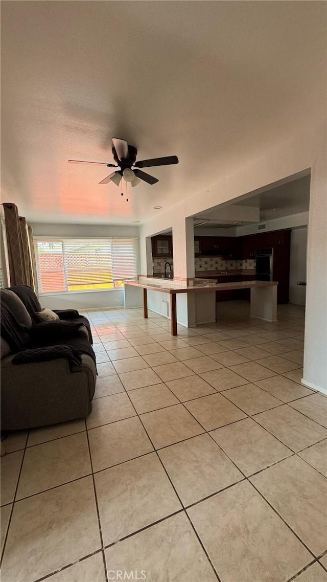 tiled living room featuring ceiling fan