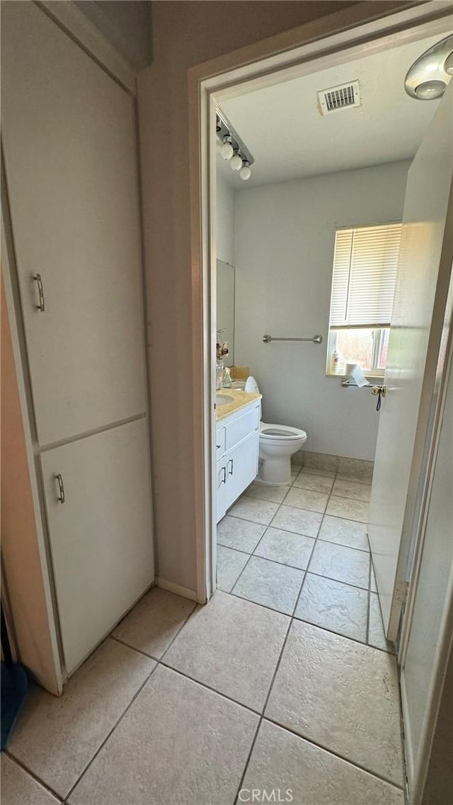 bathroom with tile patterned floors, vanity, and toilet