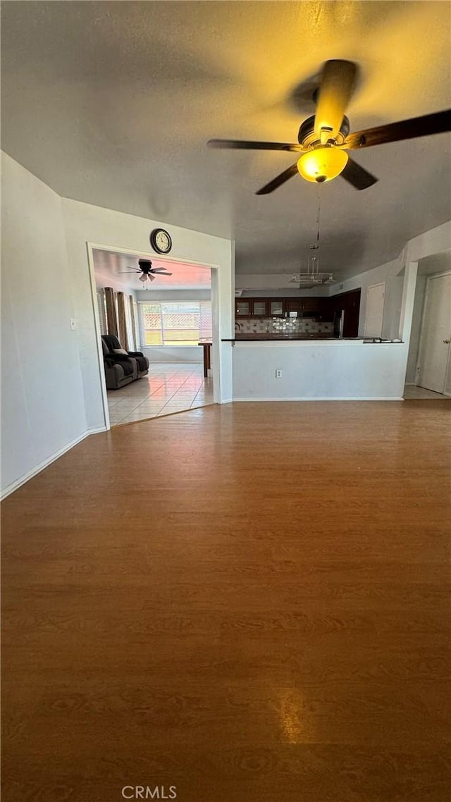 unfurnished living room with ceiling fan and hardwood / wood-style flooring