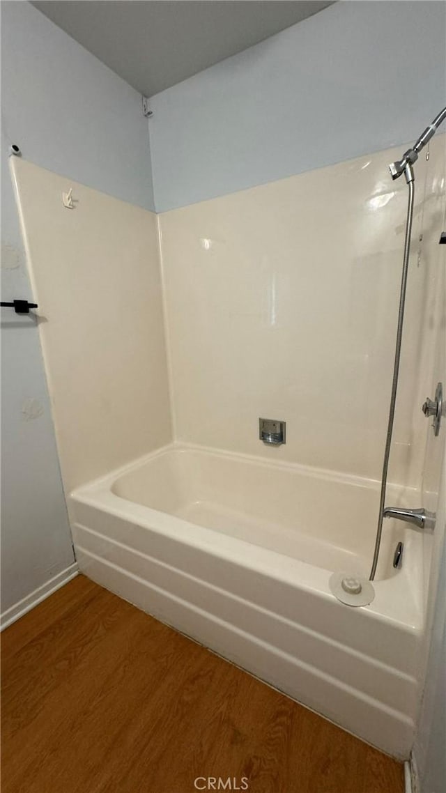 bathroom with hardwood / wood-style floors and  shower combination