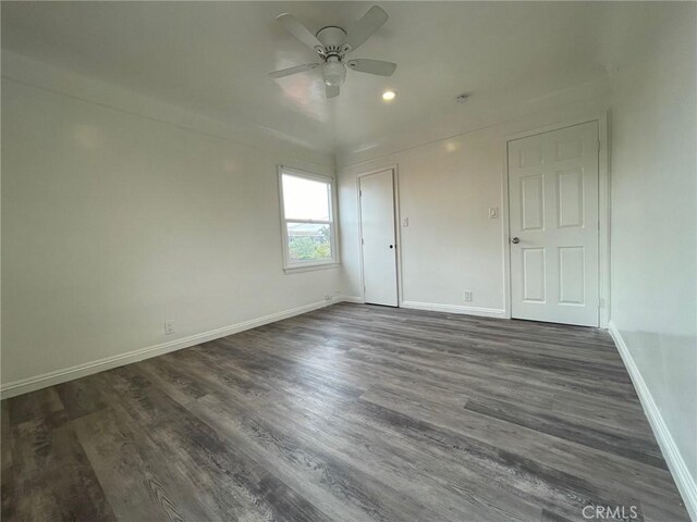 spare room featuring ceiling fan and dark wood-type flooring