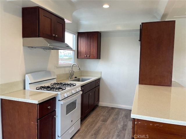 kitchen featuring gas range gas stove, dark hardwood / wood-style flooring, and sink