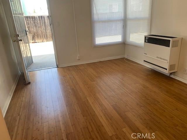 interior space featuring heating unit and hardwood / wood-style flooring