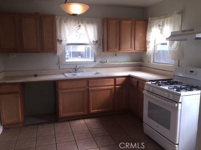 kitchen with tile patterned floors, white range with gas cooktop, plenty of natural light, and sink