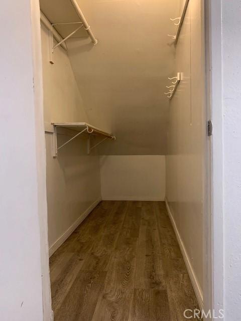 walk in closet featuring hardwood / wood-style flooring and vaulted ceiling