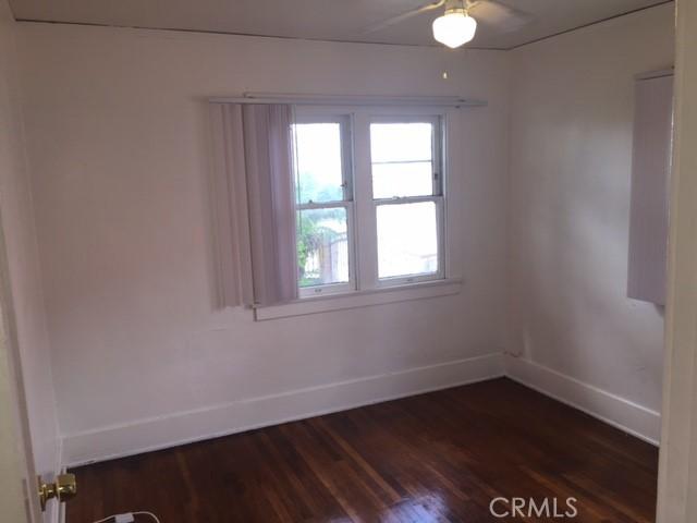 spare room with ceiling fan and dark hardwood / wood-style floors