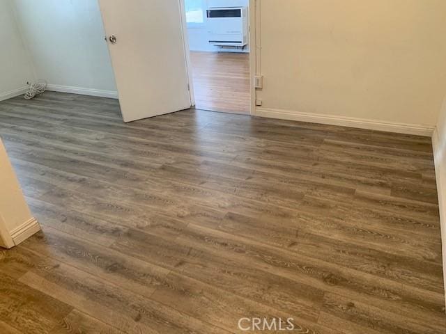 unfurnished room with dark hardwood / wood-style flooring