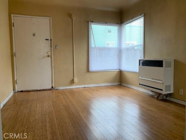 unfurnished living room with heating unit and light hardwood / wood-style flooring