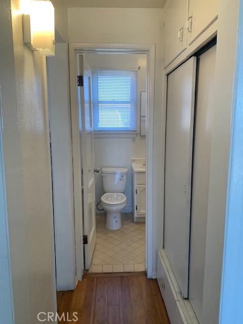 bathroom with toilet, vanity, and hardwood / wood-style flooring