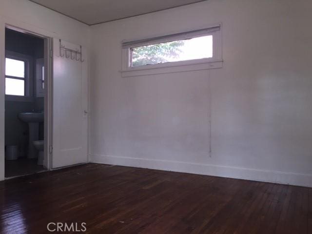 empty room with dark hardwood / wood-style floors and sink