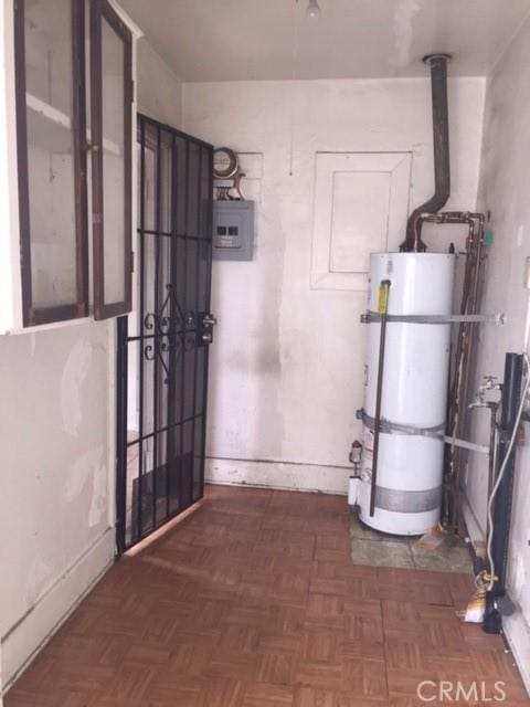 utility room featuring secured water heater and electric panel