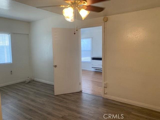 spare room with ceiling fan and dark wood-type flooring