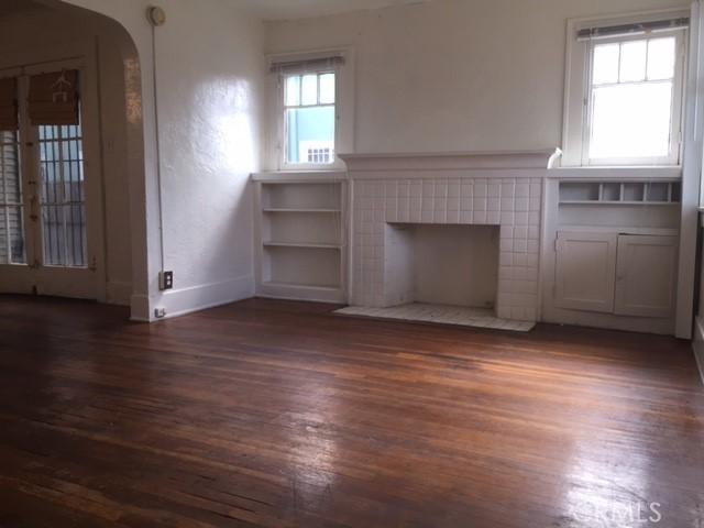 unfurnished living room with a tile fireplace and dark hardwood / wood-style floors