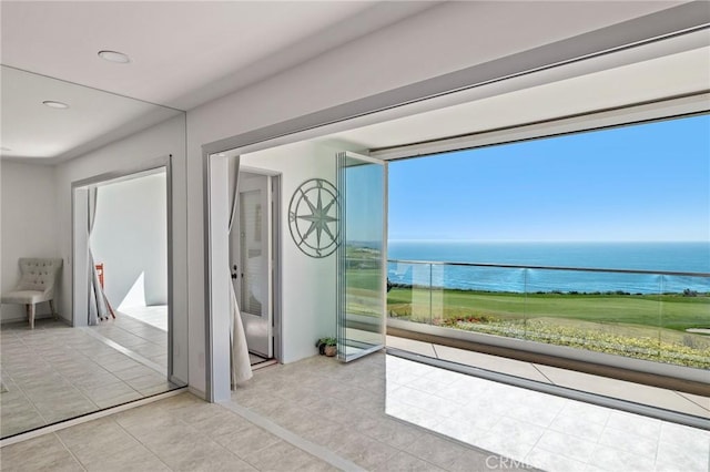 entryway featuring a water view and light tile patterned flooring