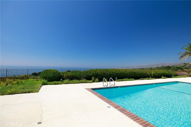 view of pool with a water view and a patio area