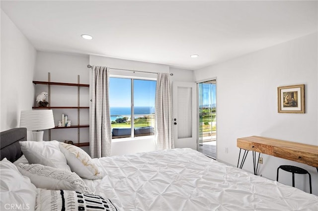 bedroom with access to exterior and a water view