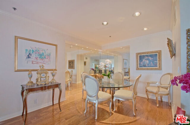 dining area with light hardwood / wood-style floors and crown molding