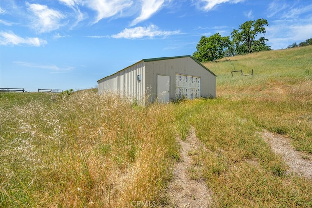 view of outdoor structure with a garage and a rural view