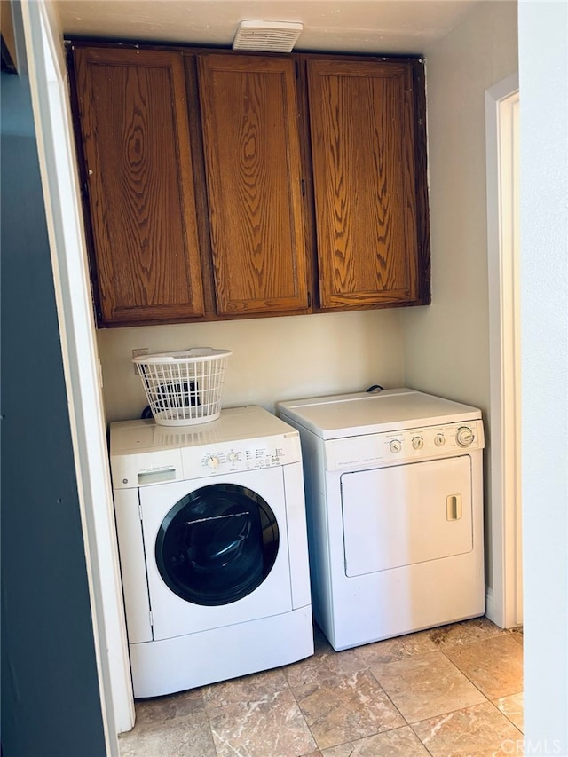 laundry room featuring cabinets and separate washer and dryer