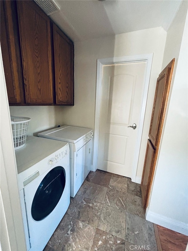 washroom with washer and dryer and cabinets