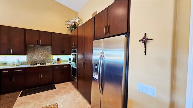 kitchen with light tile flooring, vaulted ceiling, tasteful backsplash, dark brown cabinets, and appliances with stainless steel finishes