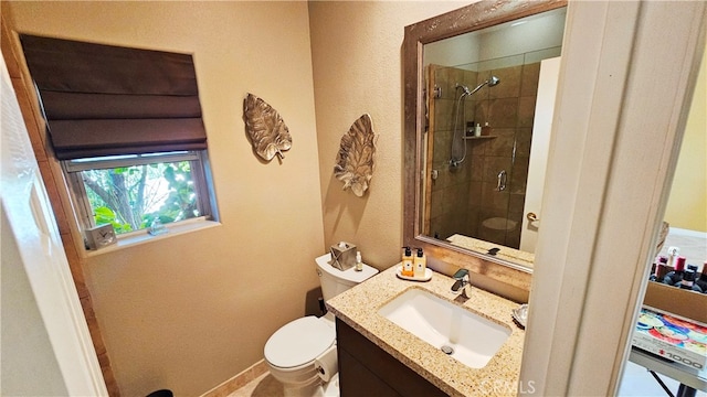 bathroom with toilet, walk in shower, and vanity with extensive cabinet space