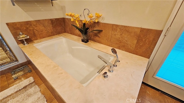 bathroom featuring a washtub and tile floors