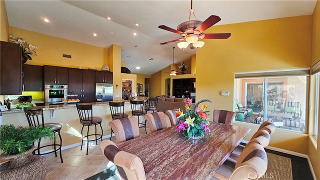 tiled dining area featuring high vaulted ceiling and ceiling fan