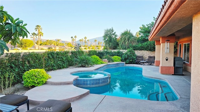 view of pool with a patio area and an in ground hot tub