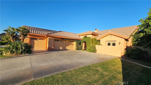 mediterranean / spanish home with a front yard and a garage