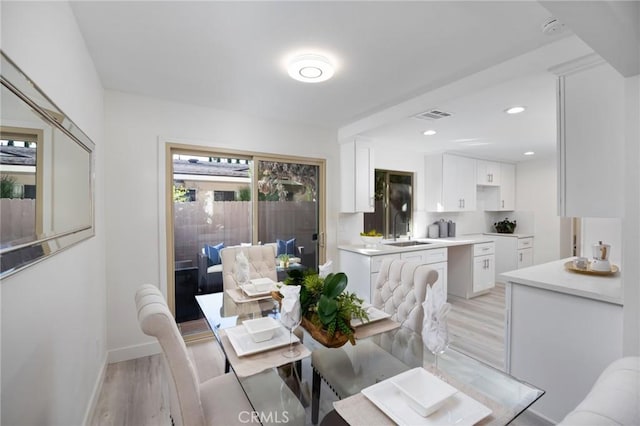 dining room featuring sink and light hardwood / wood-style floors