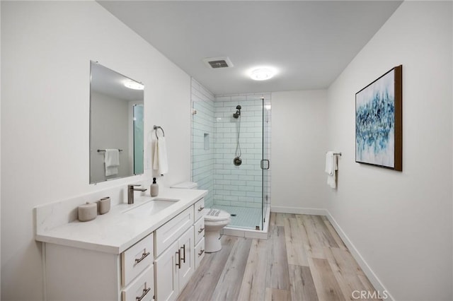 bathroom featuring vanity, hardwood / wood-style flooring, toilet, and an enclosed shower