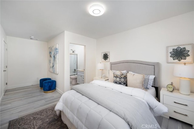 bedroom featuring connected bathroom and hardwood / wood-style flooring