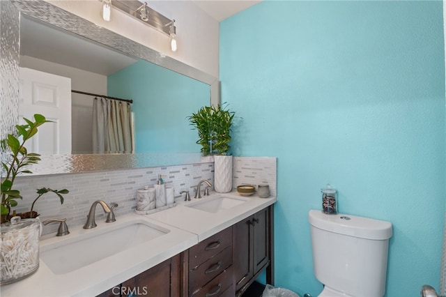 bathroom featuring decorative backsplash, vanity, toilet, and curtained shower